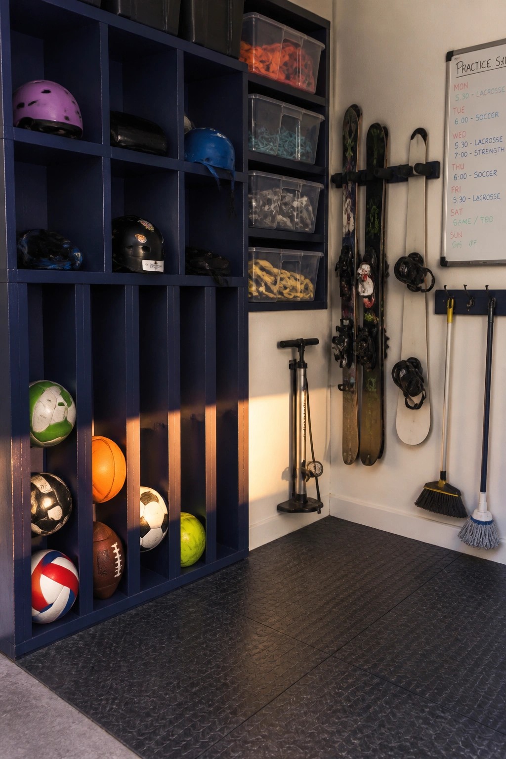 Blue cubbies stocked with balls and helmets beside wall-mounted skis and schedule board