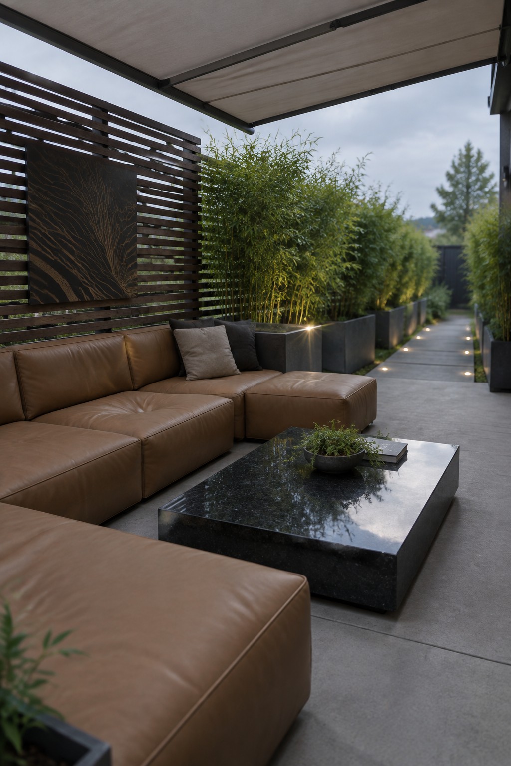 Modern outdoor patio with brown leather sectional, black marble table, and bamboo planters