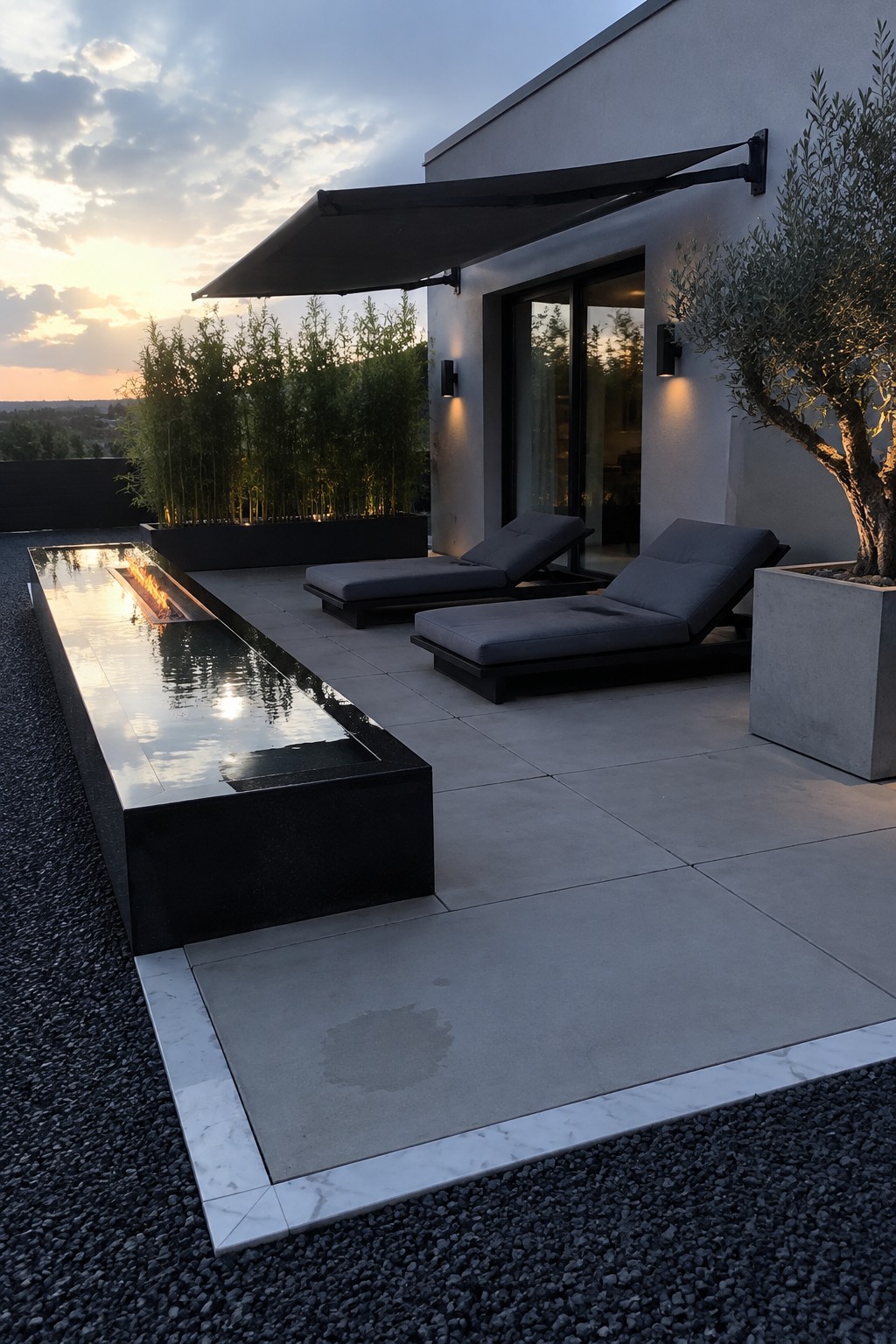 A square paved patio with large gray pavers and a light stone border beside a narrow reflecting pool.