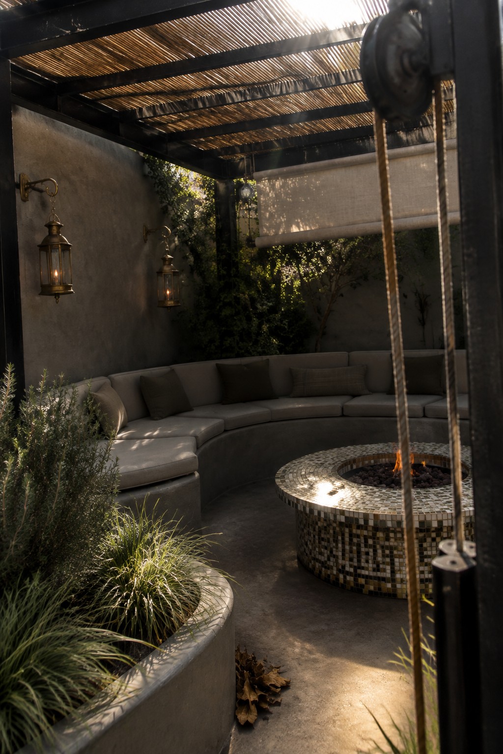 A slatted pergola shades a curved built-in sofa and round tiled fire pit on a patio.