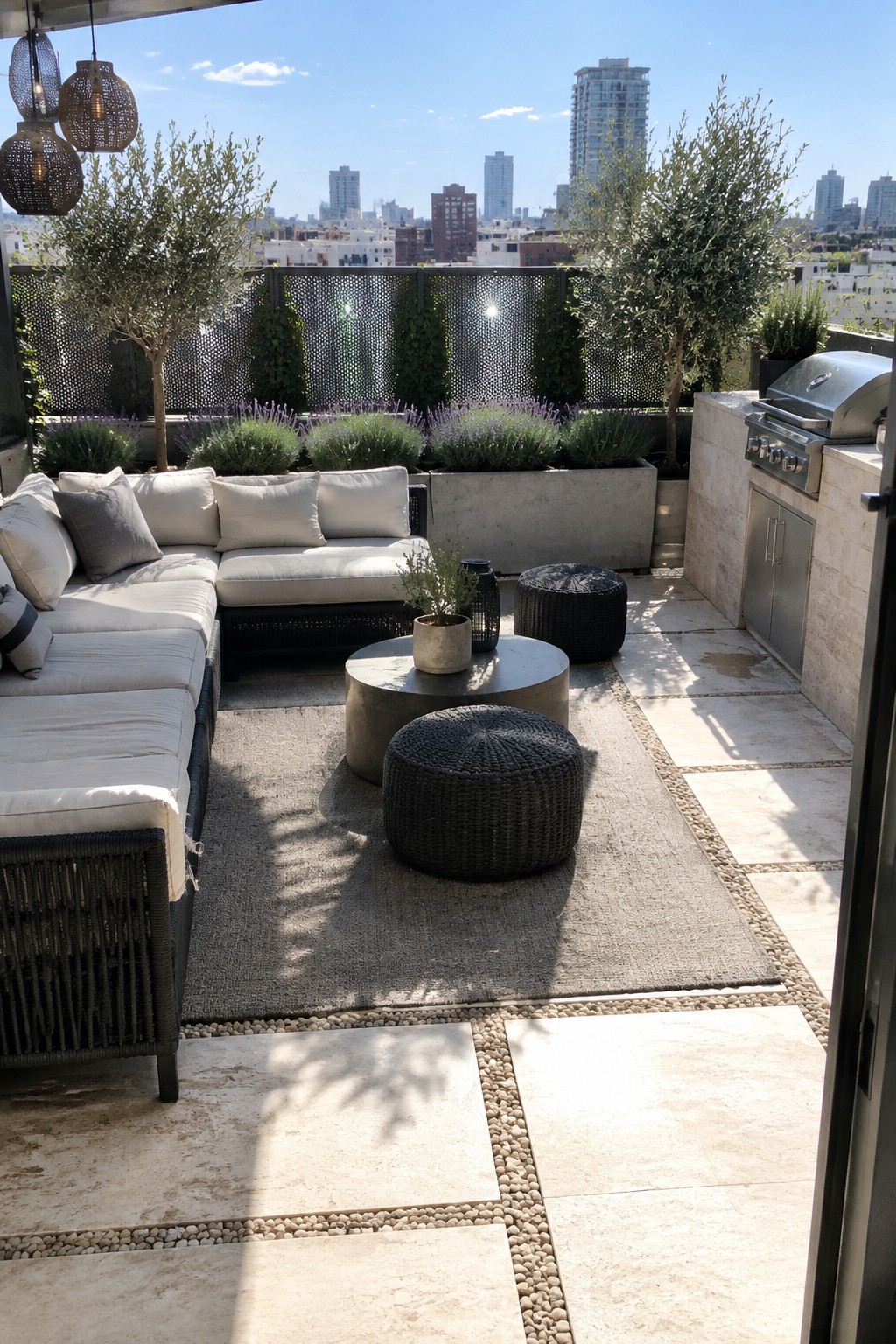 A rooftop patio with large pale stone pavers separated by narrow gravel strips, outdoor seating, planters, and a built-in grill.